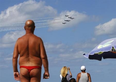 People watch the Breitling Jet Team perform aerobatics over the Mediterranean Sea from a beach in Tel Aviv